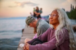 Beautiful Hawaiian senior woman enjoying sunset view from lake dock