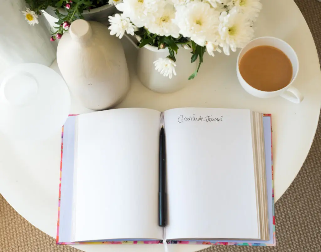 Open gratitude journal with pen and coffee, a simple daily habit.