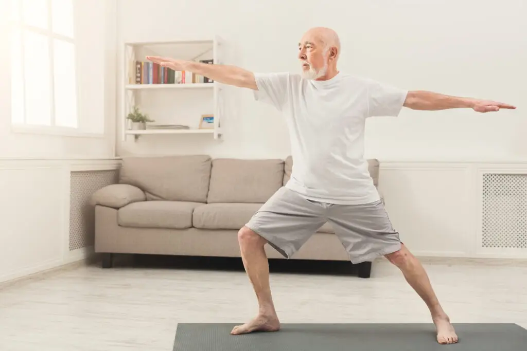 How to prevent seniors from falling? One way is practicing yoga, as this man is doing in his living room.